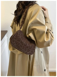 Fashionable brown leopard print hobo bag worn with a stylish autumn trench coat