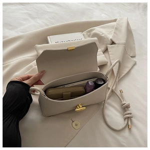 Detail view of cream crossbody bag interior showing spacious capacity and gold twist lock