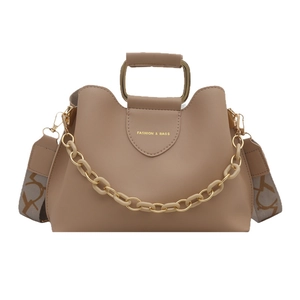 Chic beige bucket bag with metal handle, resin chain, and wide printed shoulder strap