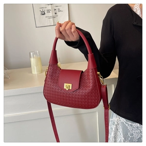 Dettaglio della borsa in pelle PU intrecciata rossa con chiusura a scatto dorata