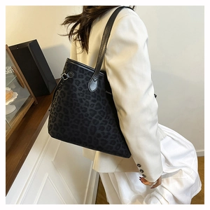 Gros plan d'un grand sac cabas à imprimé léopard porté par un mannequin en blazer chic