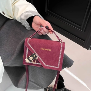 Stylish burgundy suede small square bag with chain strap and asymmetric flap design