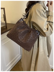 Detail view of leopard print shoulder bag with drawstring texture and silver chain strap