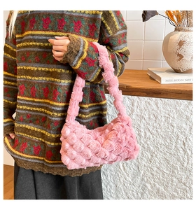 Dettaglio borsa shopper in peluche rosa con trama intrecciata 3D su maglione vintage