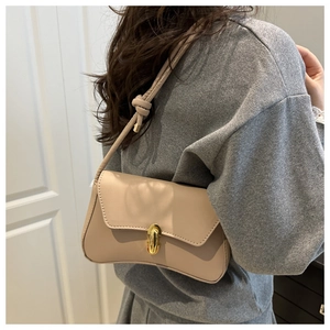 Chic beige leather crossbody bag with gold twist lock and knotted shoulder strap detail