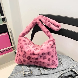 Sac fourre-tout chic en fausse fourrure léopard rose suspendu sur une chaise de style