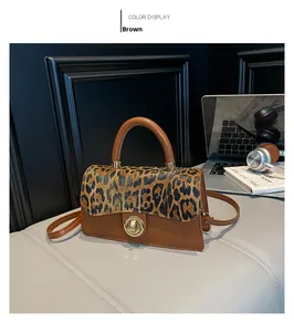Brown crossbody bag featuring a leopard print flap and a golden round rotary lock clasp