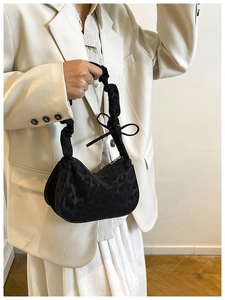 Detail of black leopard jacquard handbag with ruffled handle and decorative bow knot