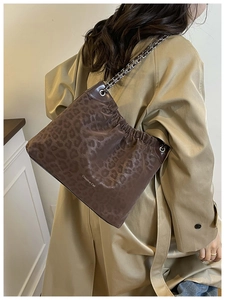 Detail of leopard print tote bag with ruched design and silver chain shoulder strap