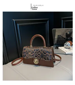 Close-up of leopard print flap on brown leather crossbody bag with gold metal lock