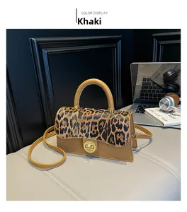 Detail of khaki crossbody bag with leopard print flap and golden metal clasp lock