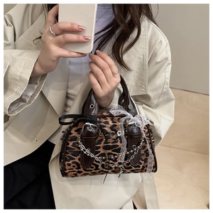 Detail of leopard print handbag with silver chain, lace trim, and black ribbon bow accents