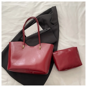 Detail of burgundy wax leather tote set with matching pouch and polished gold hardware
