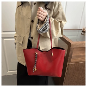 Detail of red large-capacity tote bag in premium PU leather with stylish checkered ornament