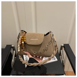 Détail du sac bandoulière en daim kaki avec perles en bois et chaîne à fleurs