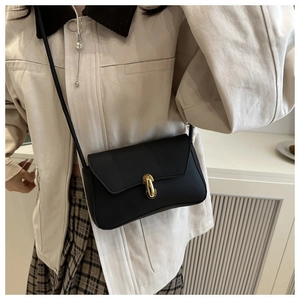 Close-up of minimalist black square crossbody bag featuring a golden capsule metal buckle