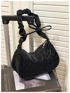Detail of black leopard print hobo bag featuring scrunchie strap and bow knot decoration
