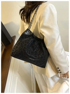 Detail of leopard print tote bag with drawstring texture and gold chain strap