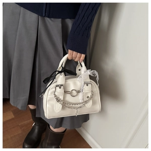 Close-up of white PU leather crossbody bag with silver chains and lace ribbon detail