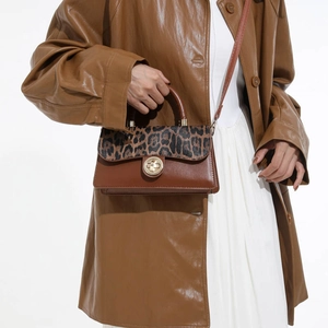 Chic leopard print crossbody bag with brown leather and gold hardware on model