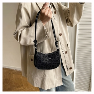 Black leopard print hobo bag with Creative Cat lettering shown on model shoulder