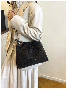 Detail of drawstring opening and silver chain strap on leopard print tote bag