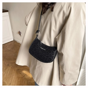 Detail shot of black leopard print underarm bag with Creative Cat text and zipper