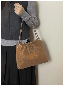 Close-up of brown leopard print shoulder bag featuring ruched detail and chain strap