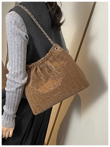 Detail of vintage leopard print tote bag with drawstring closure and chain strap
