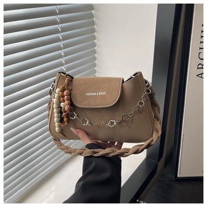 Détail d'un sac à bandoulière kaki avec perles en bois et chaîne en métal fleurie