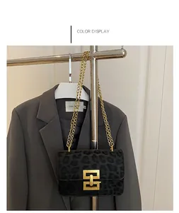 Women's black leopard print crossbody bag with gold chain strap and geometric buckle