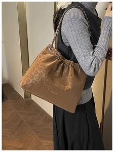 Detail of a brown leopard print shoulder bag featuring silver chain and Creative Cat text
