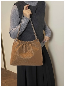 Detail of leopard print suede shoulder bag with gold chain and Creative Cat logo