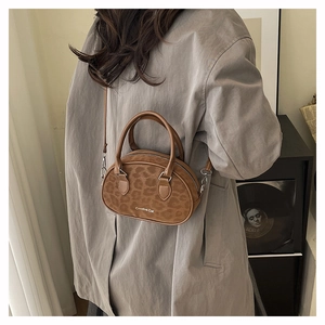Retro leopard print Boston bag with top handle and crossbody strap styled on a model