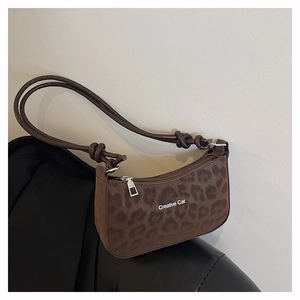 Macro shot of leopard print texture and Creative Cat text on brown shoulder bag