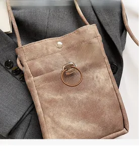 Détail d'un mini sac bandoulière marron en toile sergée avec cordon et boucle