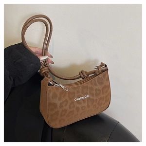 Detail of leopard print underarm bag with knotted strap and Creative Cat print
