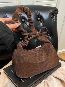 Brown leopard print crescent bag with ruffled handle and decorative bow detail