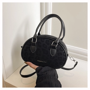 Detail showing Creative Cat black crossbody bag with subtle leopard print and matte texture