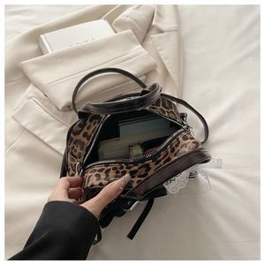 Detail shot of leopard print handbag interior capacity with smartphone and cardholder