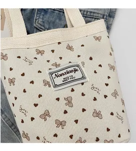 Detailed texture of corduroy strawberry tote bag with Sweet Girl bow and heart patterns