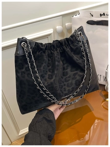 Detail of black leopard print suede tote with metal chain strap and logo engraving