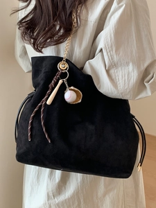 Black suede tote bag with gold chain and unique baseball glove charm accessory