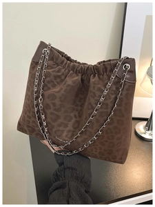 Detail view of brown leopard print tote bag with silver chain strap and drawstring closure
