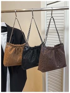 Detail of leopard print shoulder bags featuring ruched design and creative cat logo