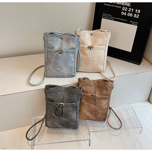 Gros plan de mini sacs de téléphone minimalistes en quatre couleurs avec cordon et boutons mats