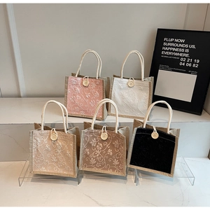 Detail of floral embroidered linen handbags in five colors with woven handles