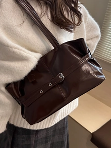 Retro large brown synthetic leather shoulder bag with buckle details on model