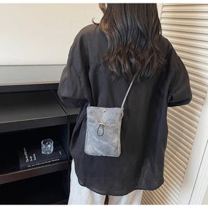 Détail de la pochette de téléphone grise avec texture mate douce et cordon de serrage