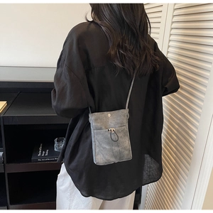 Gros plan sur un sac de téléphone minimaliste gris foncé avec texture mate et cordon serrage